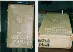 Vieille valise beige, la mention Milan Gregor, Canada inscrite dessus.