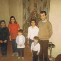 Photo en couleur d’un homme, d’une femme et de quatre enfants devant l’arbre de Noël.