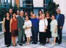 Photographie couleur récente de plusieurs membres de la famille debout à l’extérieur d’un immeuble.