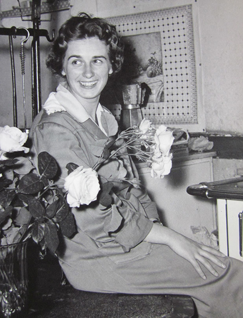 Une femme assise avec des fleurs.
