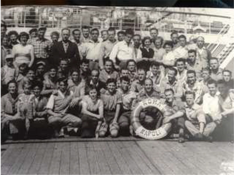 Groupe photo noir et blanc de personnes assises et debout devant le navire.