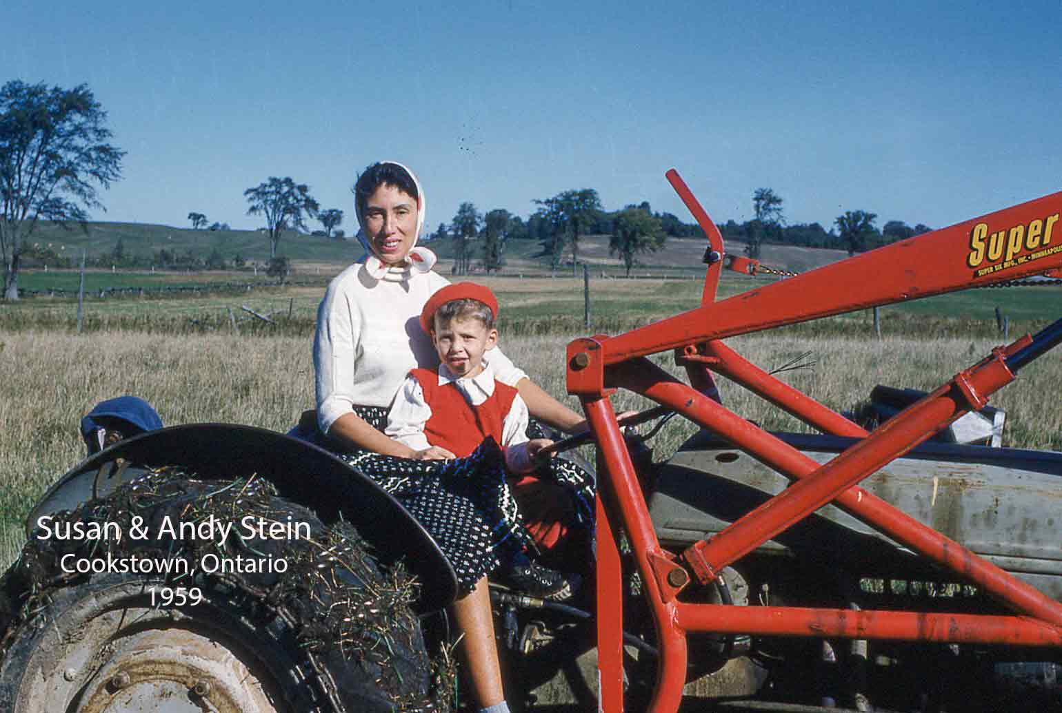 Une mère slovaque et son enfant sont assis sur un tracteur rouge et sourient à l’appareil photo.