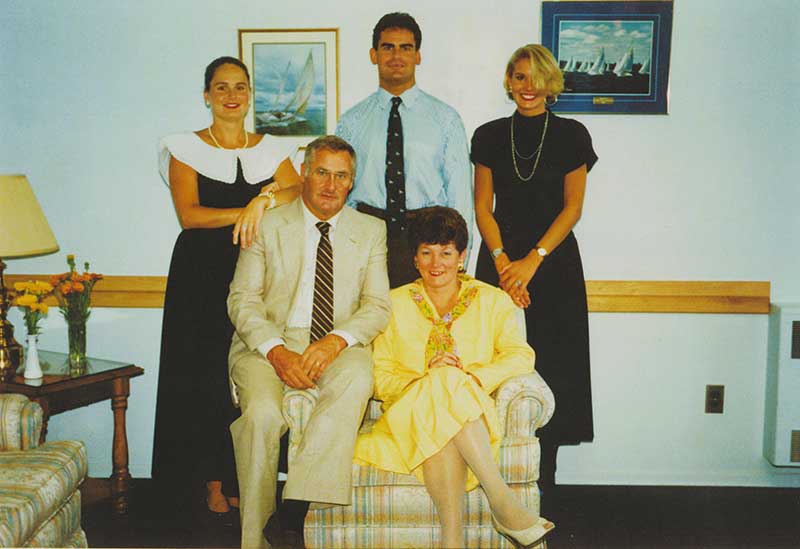 Un portrait en couleur montrant une famille de cinq membres. La mère et le père sont assis et les trois enfants adultes sont debout, derrière eux.