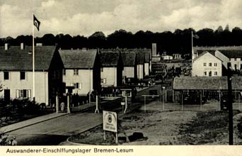 Carte postale jaunie montrant la route avec plusieurs rangées de maisons du camp de l’Allemagne.