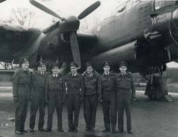 Sept jeunes hommes en uniforme debout sur le tarmac devant l’avion de guerre.