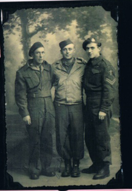 Trois hommes en uniforme devant les arbres.