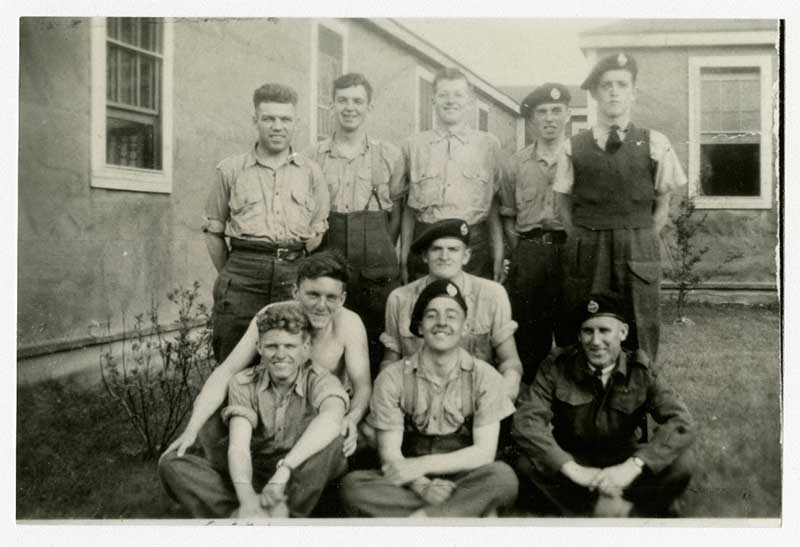 Un groupe de jeunes hommes assis et debout en posant pour une photo.