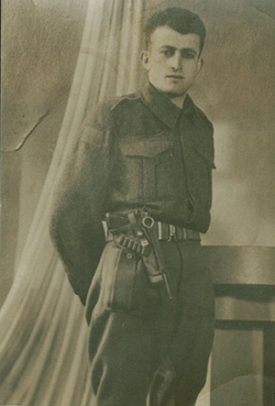 Portrait d’Ernest, jeune homme, en tenue militaire avec ceinture de fusil.
