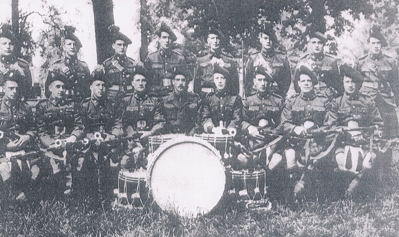 Plusieurs membres d’une fanfare militaire posent pour une photo.