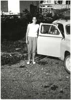 Jeune femme debout près de la portière ouverte d’une voiture.