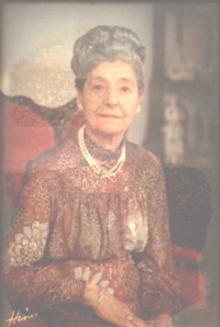 Beau portrait coloré de Sadie en femme plus âgée, portant des perles.