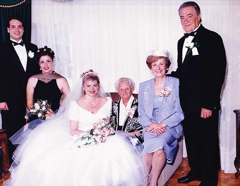 La mariée est assise sur un canapé entouré de cinq membres de la famille.