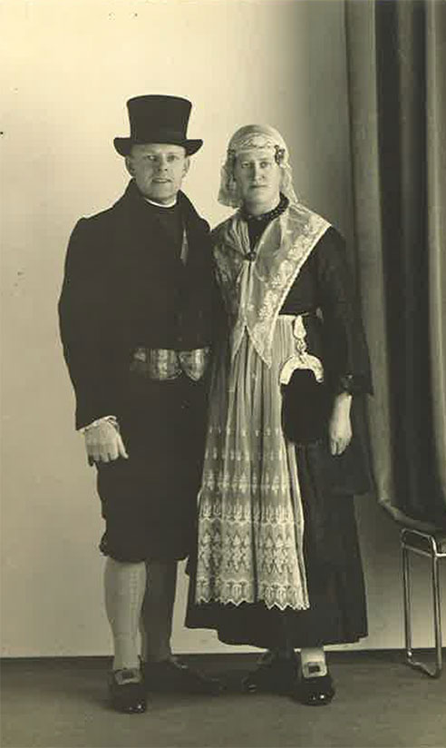 Jeune homme et femme debout devant un mur en costume.