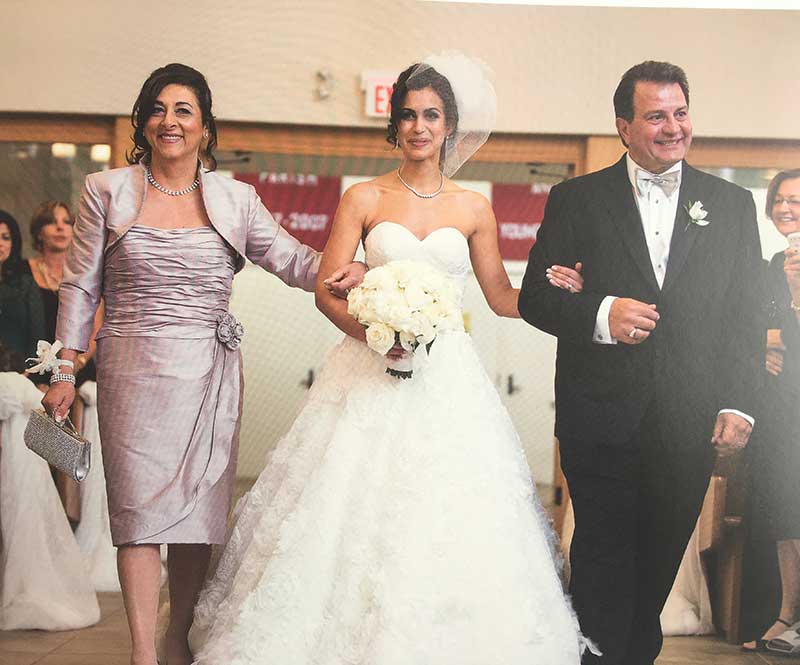 Une mariée escortée par son père et sa mère.