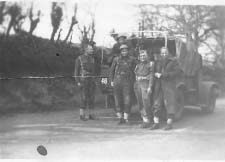 Groupe de soldats debout devant la jeep de l’armée.