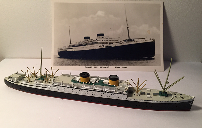 Maquette miniature du navire Britannic à côté d’une carte postale du navire.