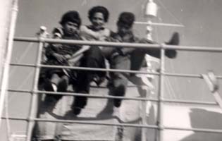 Trois membres de la famille contre la rambarde du navire.