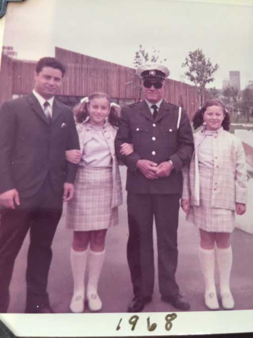 Un homme en uniforme est debout avec un autre homme et deux jeunes filles.
