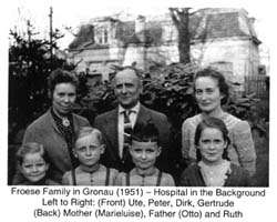 Photographie de sept membres de la famille debout devant la maison. 