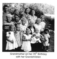 Grand-mère assise entourée de seize petits-enfants.