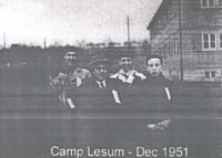 Photographie floue montrant quatre personnes debout devant un immeuble avec la légende Camp Lesum - Dec 1951.
