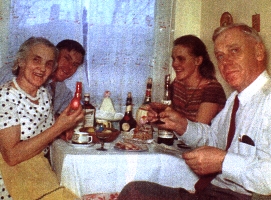 Photographie couleur montrant quatre membres de la famille assis à la table de la cuisine.