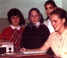 Photographie couleur montrant quatre jeunes filles assises sur un divan.