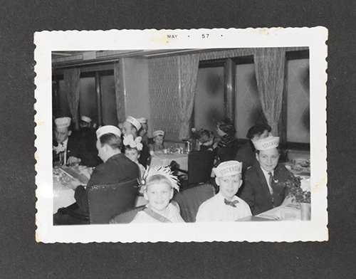 Photo en noir et blanc de la famille Danemark portant des casquettes, trois enfants sont assis pour la photo.