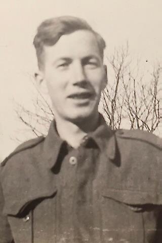 Photo sépia d’un homme souriant en uniforme.