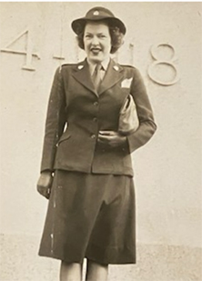 Photo sépia d’une femme blanche souriante, en uniforme.